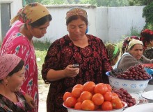Woman uses cell phone at the market - Tajikistan. By Kate Dixon.